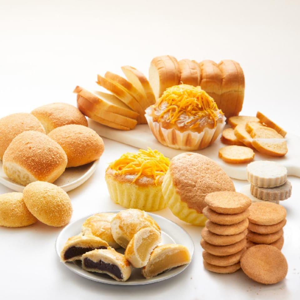 Assortment of Goldilocks Filipino baked goods, including pandesal, mamon, sliced bread, and cookies.