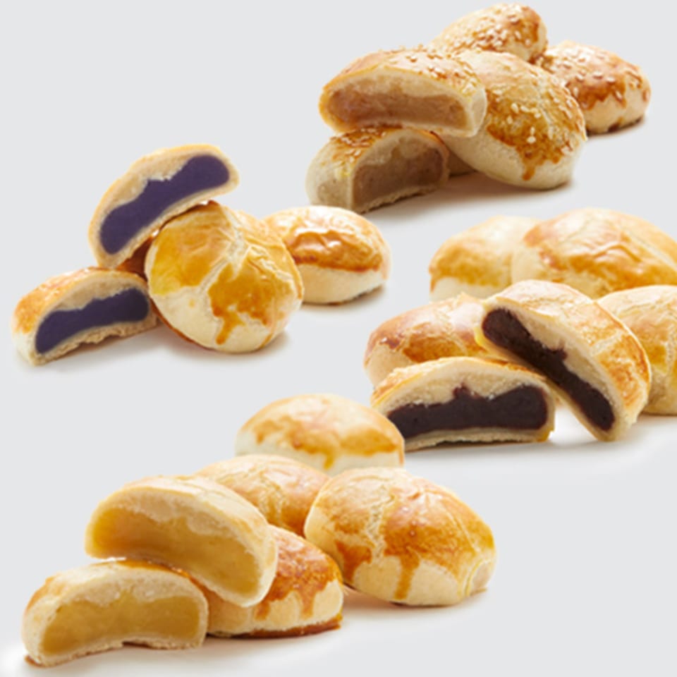 Assortment of Goldilocks Filipino pastries with various fillings, some cut in half to show the inside.
